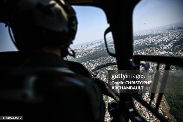 Pilot of a French army Fennec helicopter performs a reconnaissance flight over the Paris skyline with the Eiffel tower lined up, ahead of the July 14...