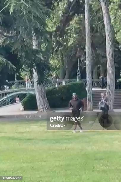 Screen grab taken from a video obtained by AFPTV on June 8, 2023 shows a man armed with a knife running away after he attacked a group of pre-school...