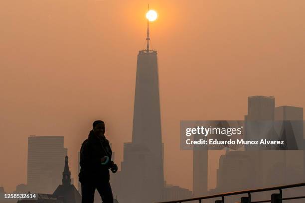 The sun rises behind The One World Trade Center while the smoke from Canada wildfires covers the Manhattan borough on June 8, 2023 in New Jersey.