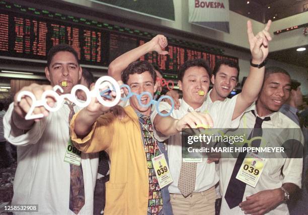 Stock traders in Sao Paulo celebrate the coming of the New Year. Corredores de la Bolsa de Valores de Sao Paulo muestran lentes relativos al 2000...