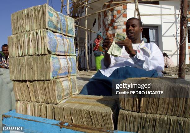 Somaliland money exchanger waits for customer in a street in Hargeisa 30 May 2001, one day before the constitutional referendum in this country. Ten...