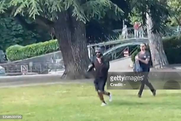 Screen grab taken from a video obtained by AFPTV on June 8, 2023 shows a man armed with a knife running away after he attacked a group of pre-school...