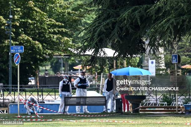 French forensic police officers work at the scene of a stabbing attack in the 'Jardins de l'Europe' park in Annecy, in the French Alps, on June 8,...
