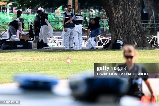 French forensic police officers work at the scene of a stabbing attack in the 'Jardins de l'Europe' park in Annecy, in the French Alps, on June 8,...