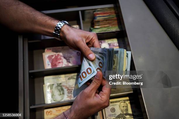 An employee counts US 100 dollar banknotes at a cash till in Istanbul, Turkey, on Thursday, June 8, 2023. Turkey's lira plunged to a record low as...