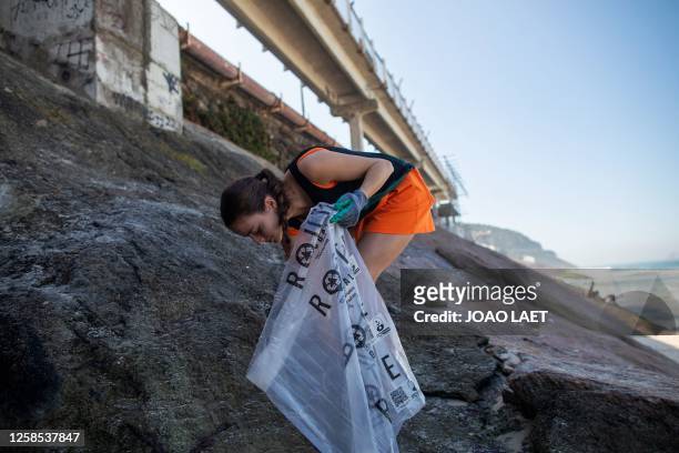 Volunteer from a Non-Governmental Organization cleans the Sao Conrado beach in Rio de Janeiro, Brazil on June 8, 2023 in the framework of the World...