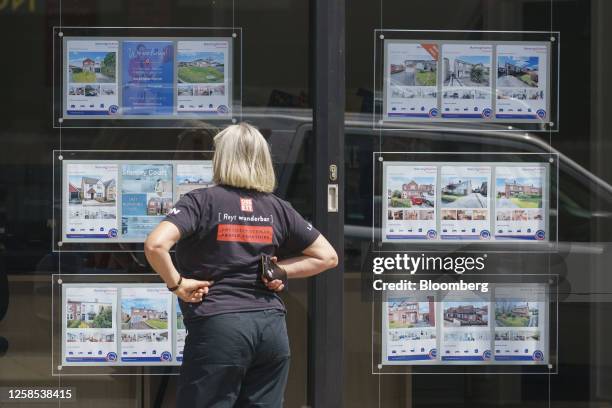 Pedestrian looks at property adverts in the window of an estate agent's in Wakefield, UK, on Thursday, June 8, 2023. UK house prices posted their...