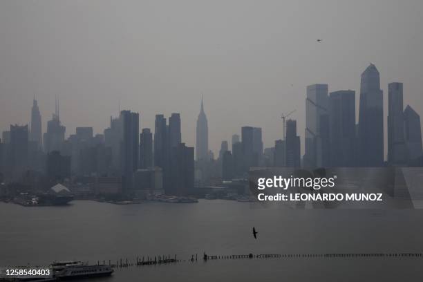 The Manhattan skyline is seen across the Hudson river from the waterfront in West New York, New Jersey, on June 08 as smoke haze from Canadian...