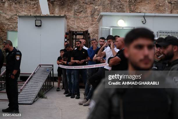 Israeli security forces and onlookers gather in front of a car wash, where five Arab Israelis were shot dead, in the village of Yafia, west of...