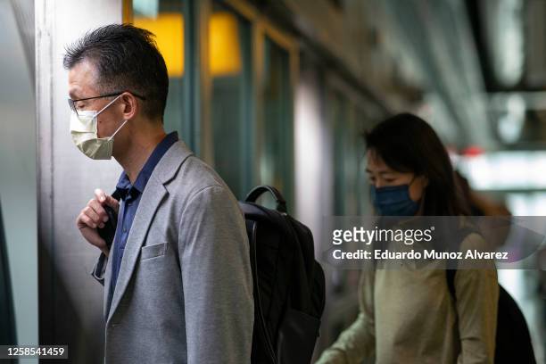 People wear face masks as they arrive to Newark Liberty International Airport amid hazy conditions due to smoke from the Canadian wildfires on June...