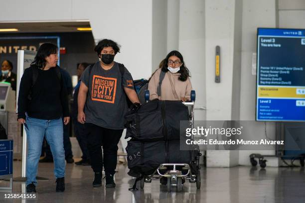 People wear face masks as they arrive to Newark Liberty International Airport amid hazy conditions due to smoke from the Canadian wildfires on June...