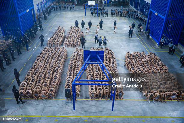 An aerial view of prisoners of gang members, whose hands handcuffed behind the back, are waited as personnel carry out a search at La Esperanza...