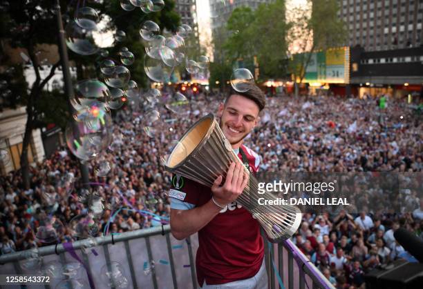 West Ham United's English midfielder Declan Rice holds the UEFA Europa Conference League trophy on stage at the Town Hall in Stratford, east London...