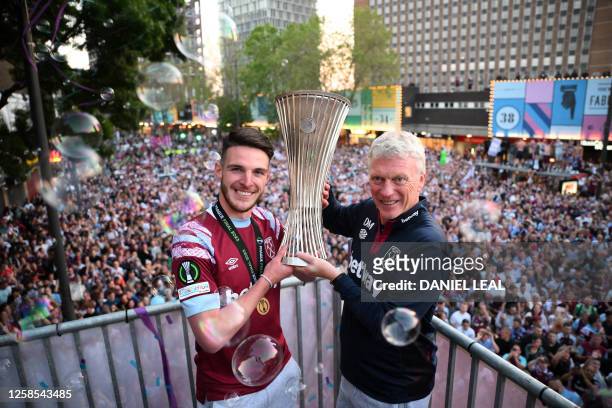 West Ham United's English midfielder Declan Rice and West Ham United's Scottish manager David Moyes hold the UEFA Europa Conference League trophy on...