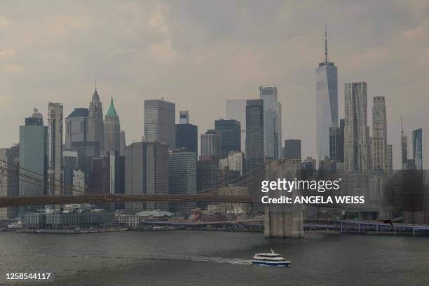 The Skyline of lower Manhattan and Brooklyn Bridge is pictured as smoke from wildfires in Canada cause hazy conditions in New York City on June 8,...