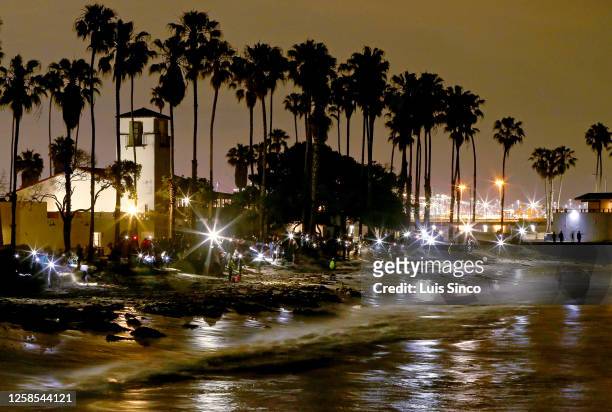 Scores of people gather at Cabrillo Beach in San Pedro to watch waves deposit thousands of mating grunion on the shore on Monday night, June 5, 2023....