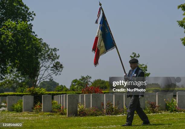 French flag-bearer honors fallen soldiers during the 79th Anniversary D-Day Service at Hottot-les-Bagues War Cemetery, in Hottot-les-Bagues,...