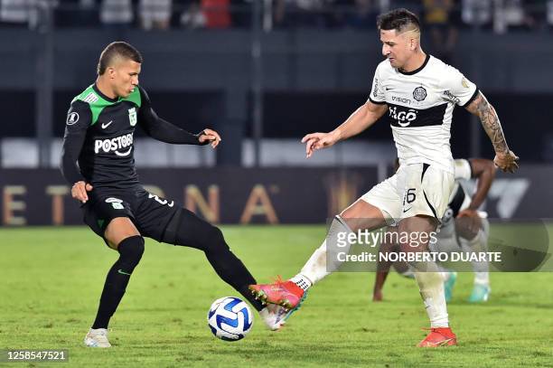 Atletico Nacional's midfielder Nelson Deossa fights for the ball with Olimpia's forward Guillermo Paiva during the Copa Libertadores group stage...