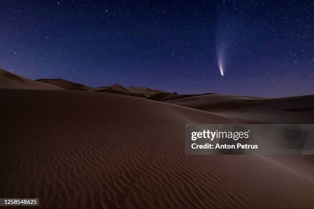 comet neowise c/2020 f3 at night over sand dune in desert - desert night stock-fotos und bilder