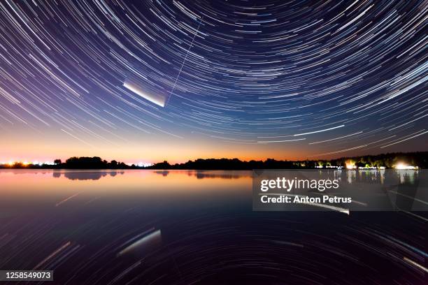 star trails over the lake. comet neowise c/2020 f3 at night over the lake. - asteroid impact stock-fotos und bilder