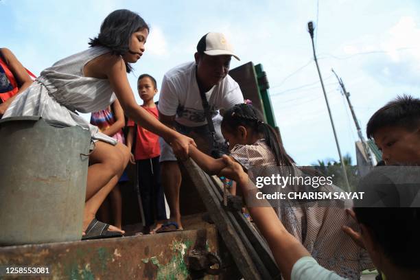 Residents board a truck as they evacuate their village due to an eruption threat from nearby Mayon volcano, in Daraga on June 9, 2023. Philippine...