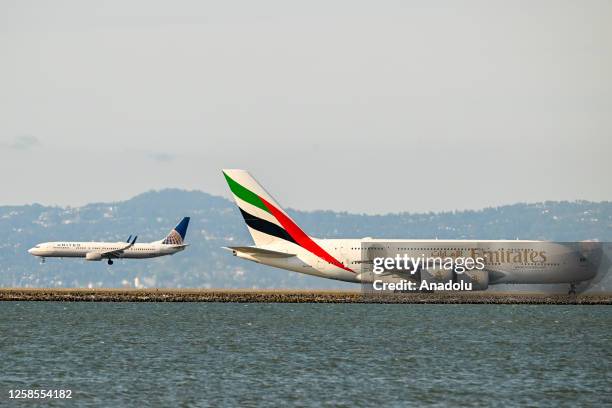 Emirates Airlines A-380 plane prepares for takeoff as a United Airlines plane is landing at San Francisco International Airport in San Francisco,...