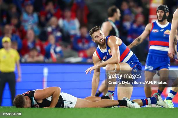 Dan Houston of the Power lays on the ground after colliding with Marcus Bontempelli of the Bulldogs during the 2023 AFL Round 13 match between the...