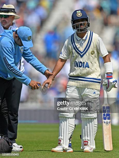 India's Ajinkya Rahane receives treatment to his hand after being hit by the ball during play on day 3 of the ICC World Test Championship cricket...