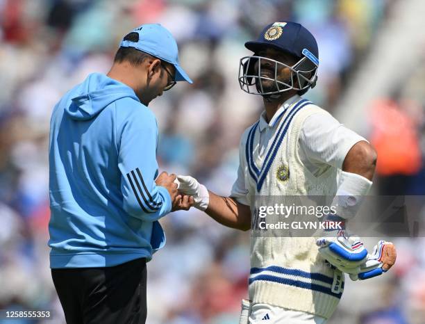 India's Ajinkya Rahane receives treatment to his hand after being hit by the ball during play on day 3 of the ICC World Test Championship cricket...