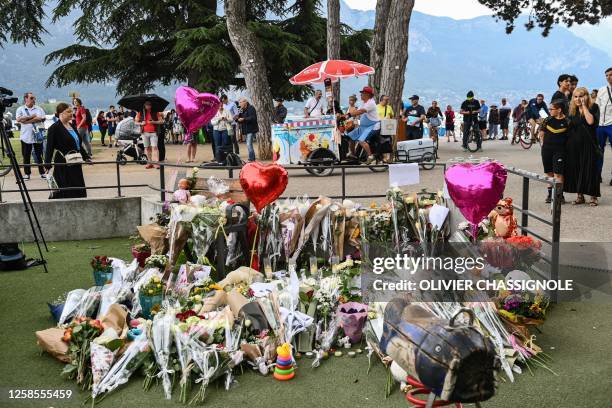 This photograph taken on June 9 shows flowers, candles and balloons laid in the 'Jardins de l'Europe' parc in Annecy, French Alps, for the victims of...