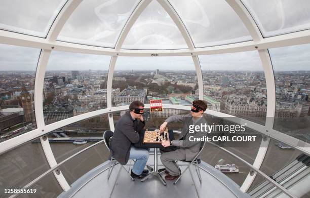 English Grand Master chess players Luke McShane and Nigel Short take part in a blindfolded game of chess in a London Eye capsule, on December 7...