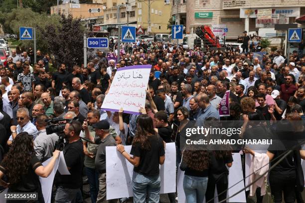 Demonstrators raise placards as they protest against the killing of five Arab Israelis in the village of Yafia, west of Nazareth, on June 9, 2023....