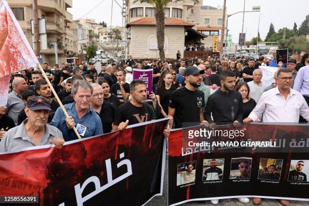 Demonstrators carry a banner bearing pictures of five Arab Israelis who were shot dead a day earlier, as they protest against their killing in the...