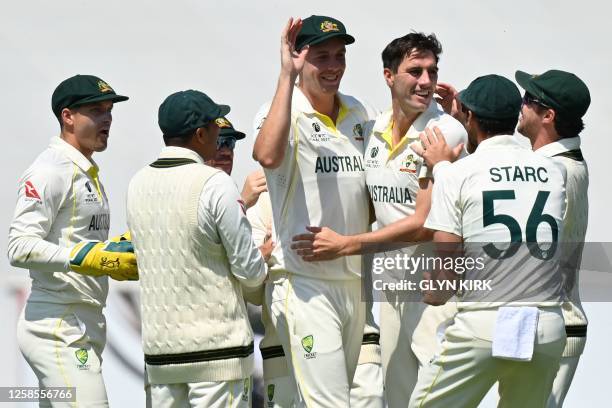 Australia's Pat Cummins celebrates with teammates after dismissing India's Ajinkya Rahane for 89 runs during play on day 3 of the ICC World Test...