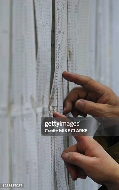 People check lists for survivors at an evacuation centre in in Natori City in Miyagi prefecture on March 14, 2011. A new explosion at a nuclear plant...