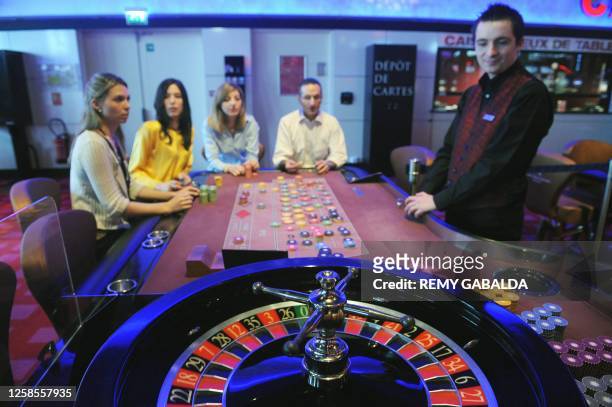 Croupier poses next to an electronic roulette on March 31, 2011 at the Theatre Barriere casino in Toulouse. AFP PHOTO REMY GABALDA