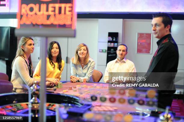 Croupier poses next to an electronic roulette on March 31, 2011 at the Theatre Barriere casino in Toulouse. AFP PHOTO REMY GABALDA