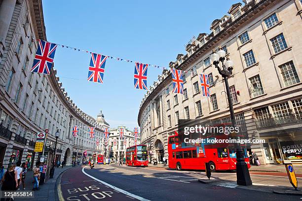 regents st with red buses and bunting - london buses stock pictures, royalty-free photos & images