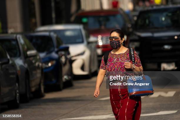 Woman wears a face mask during the morning commute due to a code orange air quality alert because of smoke from Canadian wildfires on June 9, 2023 in...