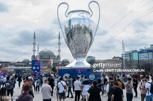 Fans mingle around a giant inflatable replica of the UEFA Champions League trophy in front of Taksim Mosque , on Taksim Square in Istanbul, on June...