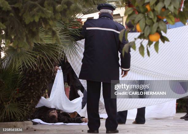 Italian policemen examine 11 December 2004 in Naples the body of Francesco Alfieri brother of former Camorra boss Carmine Alfieri who turned state's...