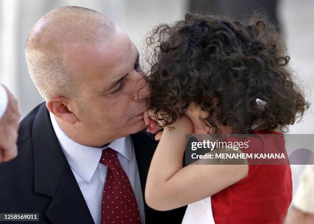 The new head of Israel's Shin Beth internal security service, Yuval Diskin, kisses his daughter before the start of a reception ceremony at the...