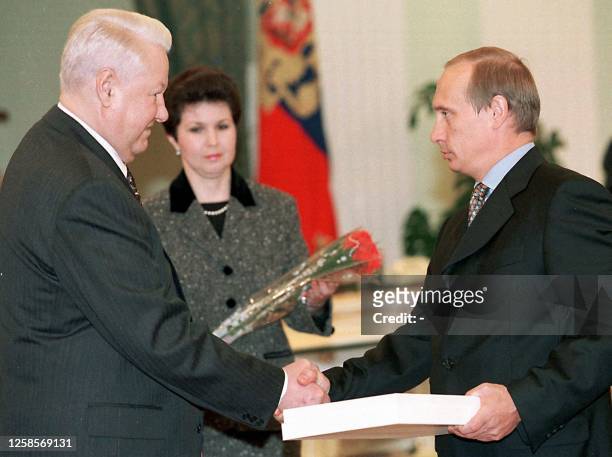 Russian President Boris Yeltsin shakes hands with the chief of the Federal Security Service Vladimir Putin, officially thanking him for the service...