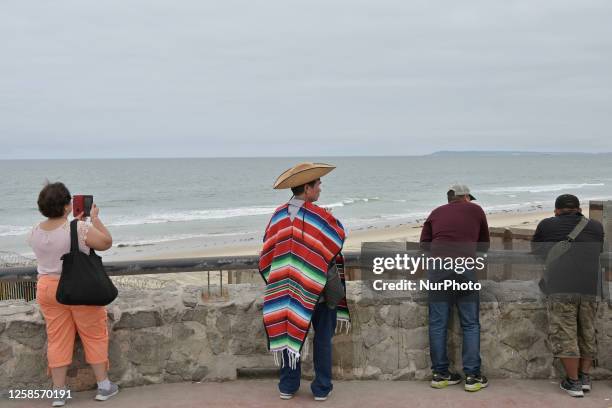 Chinese tourist is dressing in traditional Mexican costume at the site of the US-Mexico border construction in Playas de Tijuana, Mexico, on Friday,...