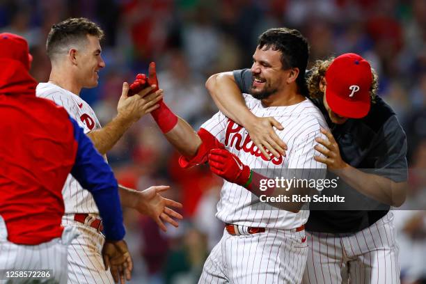 Kyle Schwarber of the Philadelphia Phillies celebrates with J.T. Realmuto and Alec Bohm after he hit a game winning home run in the ninth inning...