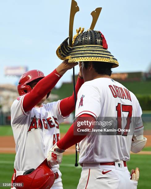 Shohei Ohtani of the Los Angeles Angels has the samurai Kabuto helmet placed on his head after hitting a two run home run in the third inning against...