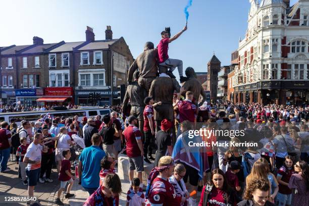 Supporters of West Ham United line Barking Road alongside The Champions sculpture and close to the club's former Boleyn Ground stadium in Upton Park...