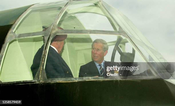 Britain's Prince Charles of Wales sits inside a replica a first Horsa glider at the Pegasus Bridge Memorial in Normandy, 05 June 2004 at Benouville....