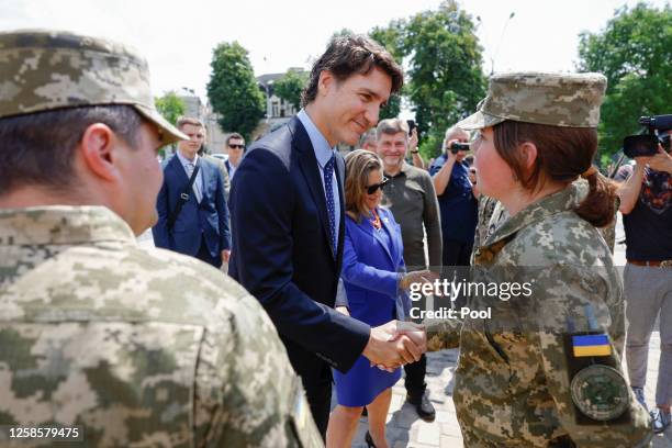 Canadian Prime Minister Justin Trudeau shakes hands with a Ukrainian soldier as he visits the Wall of Remembrance to pay tribute to Ukrainian...
