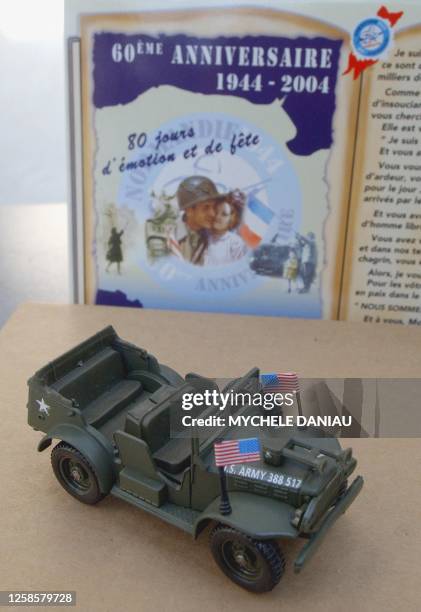 Photo prise le 17 mai 2004 à Arromanche d'une jeep miniature posée devant la carte du 60e anniversaire du Débarquement allié. De l'éclat d'obus...